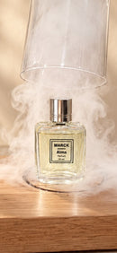 Perfume MARCK Alma 50 ml envolto em fumaça sobre uma base de madeira